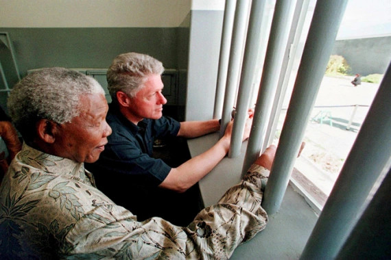 Nelson Mandela and Bill Clinton look out from the jail cell where the South African leader spent 18 years [EPA]